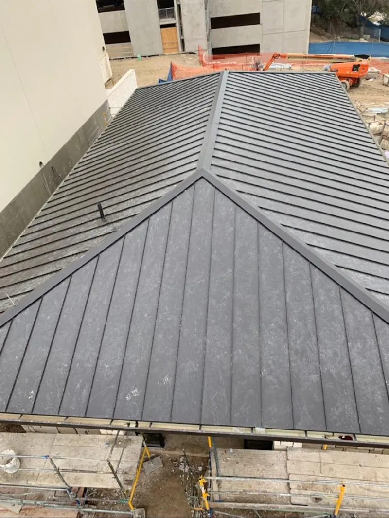 Commercial metal roof construction with crane equipment in Martin