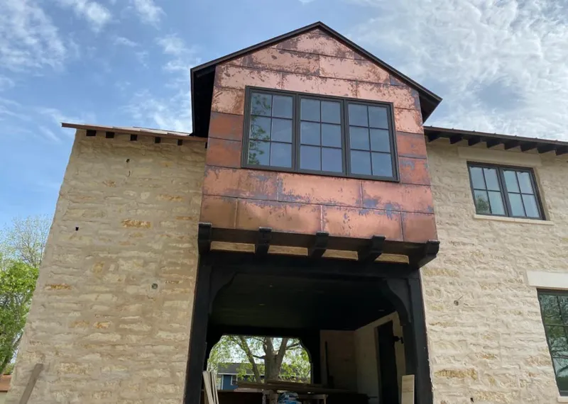 Copper metal panel facade on a stone building for Roof Repair in Martin